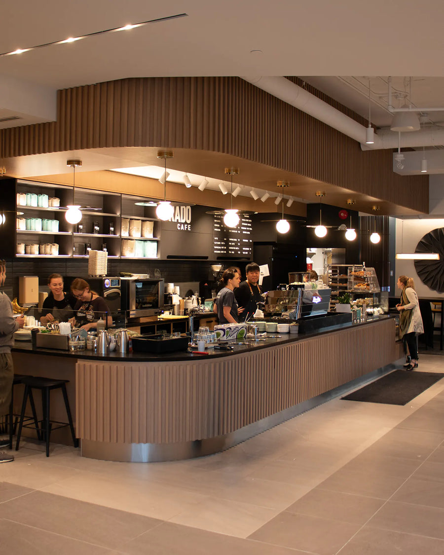 Modern cafe interior with a counter and staff working at Prado Coffee